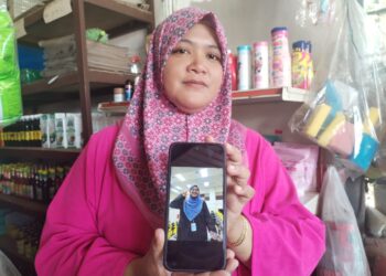 NURHASLIZA Yusof menunjukkan gambar Allahyarham Fatin Nasrien Fadli ketika ditemui di Kampung Kerandang, Besut, Terengganu. 
– UTUSAN/WAN ZURATIKAH IFFAH WAN ZULKIFLI