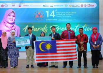 Rayyan Harith dan Al Hyfzul mengibarkan Jalur Gemilang sambil memegang cek kemenangan bagi meraikan pencapaian mereka.