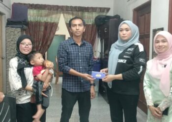 SHAM Mat Sahat (kiri) melawat keluarga kanak-kanak berusia tiga tahun yang menghadapi masalah kewangan untuk menjalani pembedahan kaki di Bagan Serai, Perak hari ini. - UTUSAN/WAT KAMAL ABAS