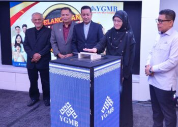 Siti Norina Muhamad bersama Abdul Muie Ngah (tengah) dan Wan Munadi Wan Mamat (kanan) menyempurnakan Pelancaran Skim Sejahtera dan Skim Kasih Warga Pendidik YGMB di Kota Bharu, Kelantan. - UTUSAN/ROSLIZA MOHAMED