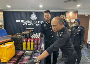 CHRISTOPHER Patit (dua dari kanan) menunjukkan jus dadah yang dirampas dalam sidang akhbar di IPD Melaka Tengah, Melaka hari ini. - UTUSAN/AMRAN ALI