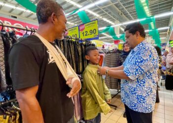 ROMLI Ishak membantu penerima bantuan memilih kelengkapan sempena program Sumbangan Kasih Ramadan dan Syawal di Alor Mengkudu, Alor Setar.