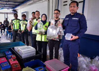 SUHANAH Kassiron (tengah) menunjukkan hasil sitaan ikan hiasan yang dilarang semasa sidang media hari ini. - UTUSAN/M. FIRDAUS M. JOHARI