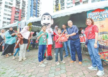 PENGARAH Eksekutif Ajinomoto (Malaysia) Berhad, Yong Kum Cheng menyerahkan
bubur lambuk kepada penduduk Perumahan Awam Seri Sabah, Cheras pada Program
Kongsi Berkat Bubur Lambuk, kelmarin. – UTUSAN/AMIR KHALID