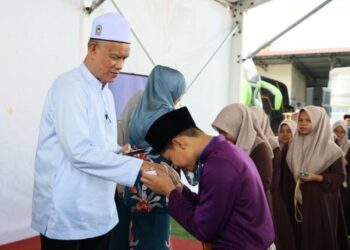 CHE Ibrahim Che Ismail (kiri) menyampaikan sumbangan kepada penerima semasa majlis Sumbangan Zakat E-Mutiara di Kota Bharu, Kelantan, hari ini. - UTUSAN/KAMARUL BISMI KAMARUZAMAN