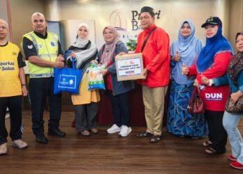 MARHAMAH Rosli (tiga dari kiri) menyampaikan sumbangan bakul makanan kepada penerima sempena program Singgah Sahur Bulan Wakaf Malaysia di Pantai Kundor, Melaka, hari ini. - UTUSAN/AMRAN ALI