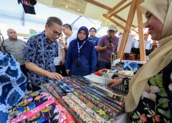 Menteri Komunikasi yang juga Ahli Parlimen Lembah Pantai, Datuk Fahmi Fadzil (dua kiri) melawat reruai jualan ketika hadir pada Majlis Bazar Raya NADI di NADI PPR Kerinchi di sini hari ini. GAMBAR: FARIZ RUSADIO / PEMBERITA: FATIN