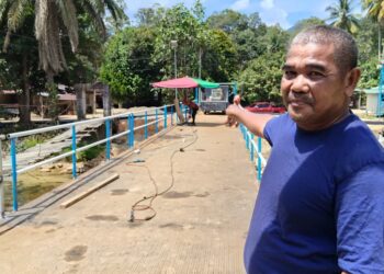 WAN Syukri Wan Isa menunjukkan kerja-kerja pembinaan jambatan besi hampir siap sepenuhnya bagi menggantikan jambatan gantung yang runtuh di Kampung Chatel Damai, Kuala Krai, Kelantan hari ini-UTUSAN/YATIMIN ABDULLAH