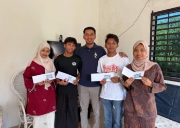 DARI kiri Sara Izzatul Fazlina Mohd. Nazri, Shahril Amirul Amir, Shahril Izzat dan Sarah Sofia Izza menerima kad pengenalan masing-masing sambil ditemani Ketua Pemuda UMNO Bahagian Indera Mahkota, Nik Mohd. Ridzuan Kamarudin (tengah) di Kampung Cherating di Kuantan, Pahang.