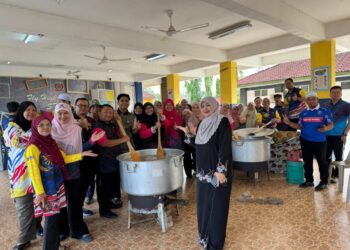 GURU-guru bergoyong-royong menyediakan bubur lambuk tulang ‘gear box’ bagi diagihkan kepada lebih 1,400 murid dan warga sekolah di Sekolah Tengku Budriah (STB) Arau, Perlis semalam.-UTUSAN