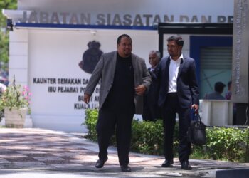 NIZAMUDDIN Hamid (kiri) selepas memberi keterangan selama tiga jam di Bukit Aman, Kuala Lumpur, semalam.