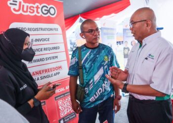 MAHADZIR Maso’d (kanan) memberi penerangan kepada pengguna mengenai sistem pembayaran tol terbuka pada Program Kesedaran Penunggangan Selamat berhampiran Plaza Tol Juru Arah Utara di Bukit Mertajam, Pulau Pinang. – UTUSAN/DANIAL SAAD