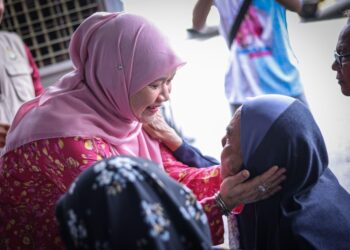 FADHLINA Sidek menyantuni salah seorang penerima bantuan Aidilfitri di Parlimen Nibong Tebal.