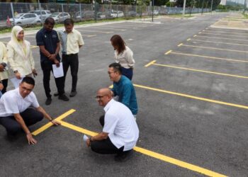 H’NG Mooi Lye (duduk, kiri) bersama A. Rajendran (duduk, kanan) ketika meninjau tempat letak kereta Fasa 2 Gurney Bay, Persiaran Gurney di George Town, Pulau Pinang, hari ini. - UTUSAN/DANIAL SAAD