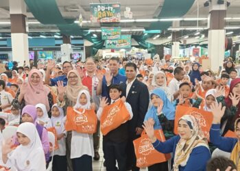 MOHD. Hisamudin Yahaya (dua dari kiri) menyerahkan sumbangan kepada murid tidak berkemampuan dari sekolah rendah sekitar Putrajaya.