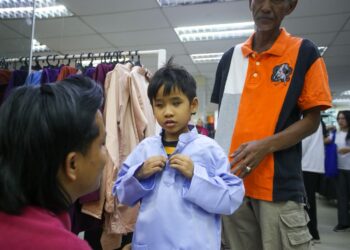 TASRYES Suhailys Roslan ditemani Roslan Hashim mencuba baju Melayu pada Majlis Sumbangan Aidilfitri Asnaf dan Anak Yatim UMNO Bahagian Alor Setar, Kedah. – UTUSAN/SHAHIR NOORDIN