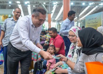 MENTERI Pengangkutan, Anthony Loke Siew Fook ketika memberikan duit raya kepada penumpang KTMB pada Majlis Edaran Pek Hari Raya Aidilfitri 2026 di KL Sentral di sini, hari ini. - UTUSAN/SYAKIR RADIN