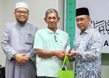 TAKIYUDDIN Hassan (kanan) menyampaikan sumbangan kepada Penggerak Pas Kota Bharu di Kota Bharu, Kelantan. - UTUSAN/YATIMIN ABDULLAH