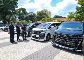 M. Kumar (kanan) melihat kenderaan mewah yang disita pada sidang akhbar Op Lejang Mewah Klon di Pulapol Kuala Lumpur hari ini. - UTUSAN/SYAKIR RADIN