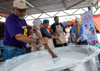 TENGKU Khalidah Tengku Bidin (kanan) bersama ahli kariah Masjid Al-Huda, Paya Jaras, Sungai Buloh bergotong-royong memasak bubur lambuk  sempena Program Kongsi Berkat anjuran Pertubuhan Keselamatan Sosial (PERKESO) dan Media Mulia Sdn. Bhd., kelmarin. – UTUSAN/ M. FIRDAUS  M. JOHARI