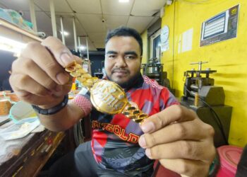 MOHAMMAD Afif Azman menunjukkan salah satu reka bentuk rantai tangan yang dihasilkan di Pertukangan Mz Gold Sdn. Bhd, Kota Bharu, Kelantan. – UTUSAN/YATIMIN ABDULLAH