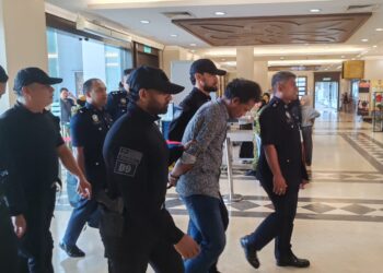 TERTUDUH, P. Sangara Lingam dikawal ketat anggota polis semasa tiba di lobi Kompleks Mahkamah Kuala Lumpur, hari ini. -UTUSAN