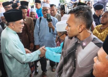ANWAR Ibrahim (kiri) bersalaman dengan jemaah ketika hadir menunaikan solat Jumaat di Masjid Asy-Syakirin Kampung Pelet, Bukit Mertajam, Pulau Pinang hari ini.-UTUSAN/DANIAL SAAD