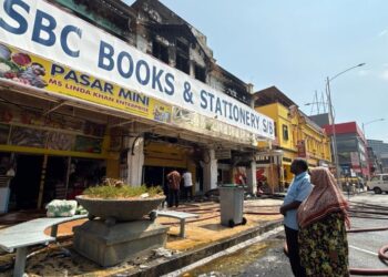 KADER Mohideen Basheer Ahmed dan adiknya, Asmah Basheer Ahmed melihat kedai buku yang berusia 58 tahun milik keluarganya yang musnah dalam kebakaran malam semalam. - UTUSAN/NOR SHAFIQAH MOHD. GHAZALI