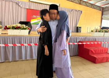 SEPU memeluk dua anaknya sempena sambutan Syawal di PRP Kuala Krai, Kelantan.