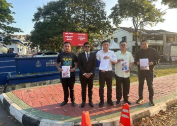 LIM Zheng Han (tengah) menunjukkan laporan polis yang dibuat berhubung penyebaran maklumat palsu berkaitan Hospital Bukit Mertajam di hadapan Ibu Pejabat Polis Daerah (IPD) Seberang Perai Tengah, Bandar Perda, Bukit Mertajam, Pulau Pinang.