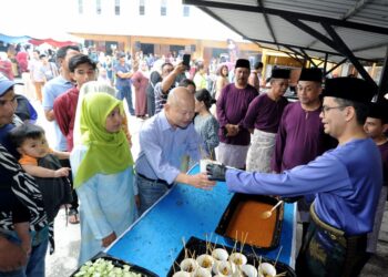 AKMAL Nasrullah Mohd. Nasir (kanan) menyantuni orang ramai yang hadir pada Majlis Hari Raya Aidilfitri Parlimen Johor Bahru di SMK Bandar Baru UDA, Johor Bahru, Johor semalam. – UTUSAN/RAJA JAAFAR ALI