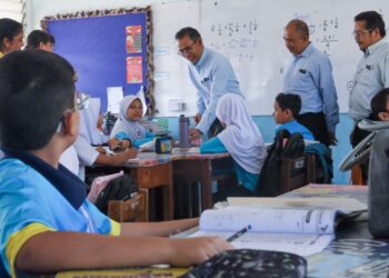 MOHAMAD Dziauddin Mat Saad (tengah) ketika turun padang meninjau kesediaan sekolah untuk mematuhi garis panduan yang ditetapkan berkaitan cuaca panas di SK Sungai Gelugor, George Town, Pulau Pinang.-UTUSAN/DANIAL SAAD