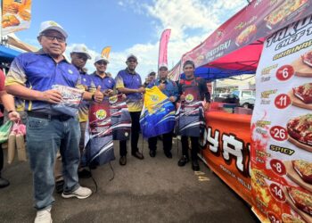 ABU Bakar Hamzah (dua dari kanan) dan Affendi Rajini Kanth (tiga dari kanan) menyerahkan apron kepada peniaga bersempena program walkabout bazar Ramadan MPK di bazar Ramadan Arau, Perlis semalam.-UTUSAN/MOHD. HAFIZ ABD. MUTALIB
