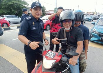 AZLI Mohd. Noor ( kiri) mengagihkan lauk percuma pada Program Agihan Lauk Ramadan Percuma di Gong Badak, Kuala Nerus , Terengganu.