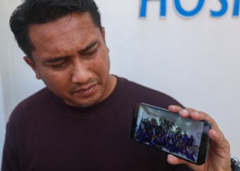 MOHD. Tarmizi Said menunjukkan gambar kenangan majlis perkahwinan bersama keluarga mangsa yang maut dalam kemalangan di Kilometer 59 Jalan Jerangau-Jabor berhampiran Felda Jerangau sewaktu diitemui di Jabatan Perubatan Forensik Hospital Sultanah Nur Zahirah (HSNZ), Kuala Terengganu, Terengganu  -UTUSAN/PUQTRA HAIRRY
