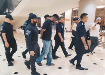 V. Vadivelu (tengah) dikawal ketat anggota polis semasa tiba di Kompleks Mahkamah Kuala Lumpur hari ini.