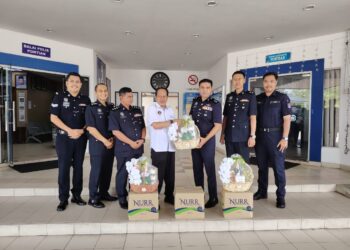 AHMAD Maslan (tengah) menyampaikan hamper kepada Ketua Polis Daerah Pontian, Hadzrat Hussein Mion Hussain ketika melawat IPD Pontian, hari ini.