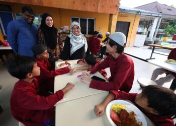 SUHAINI Bakri (kiri) menyantuni penghuni rumah anak yatim Yayasan An-Nur Maisarah di Chemor, Ipoh