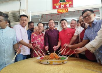 DOMINIC Lau Hoe Chai (tengah) menggaul yee sang bersama tetamu pada majlis sambutan Tahun Baharu Cina parti Gerakan di Ipoh, Perak hari ini. - FADZIL ZAINOL