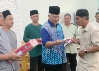 HAMZAH Zainuddin menyampaikan sumbangan kepada masjid dan surau di Madrasah Hafizah Sungai Bayor Selama di Larut. -  UTUSAN/WAT KAMAL ABAS