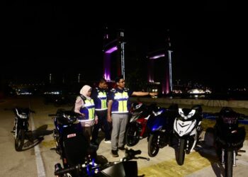 MOHD. Zamri Samion (kanan) melihat motosikal yang disita dalam operasi khas di Jambatan Angkat Kuala Terengganu, Terengganu. -UTUSAN/PUQTRA HAIRRY