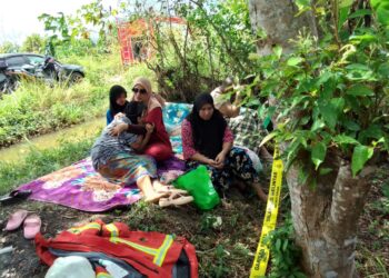 ROHANI Mohamed ditenangkan keluarganya selepas melihat jenazah anaknya yang diusung keluar dari lokasi kebakaran di Kampung Mujur, Jelawat dekat Bachok, Kelantan.