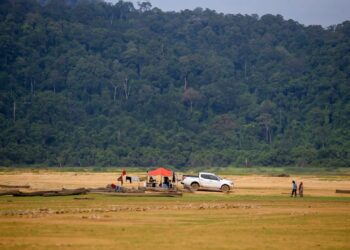 PENGUNJUNG mendirikan khemah di tengah-tengah Empangan Pedu yang kering dan merupakan perkampungan lama dikenali sebagai Kampung Mong Gajah di Pedu, Padang Terap. – UTUSAN/ SHAHIR NOORDIN