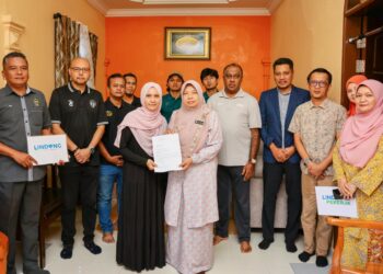 FARIHAH Che Hussin (enam dari kanan) menyampaikan faedah pencen penakat kepada Nik Noratiza Nik Abd Azi (empat dari kiri)  di Kampung Baru Gong Badak, Kuala Nerus, Terengganu. - UTUSAN/PUQTRA HAIRRY