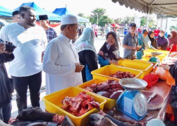 AMINUDDIN Harun menyantuni pembeli dan peniaga pada Program Mantai Raya di Masjid Dato' Klana Petra Lela Mohd Yusof, Sikamat, Seremban, Negeri Sembilan hari ini.-UTUSAN/MOHD. SHAHJEHAN MAAMIN.