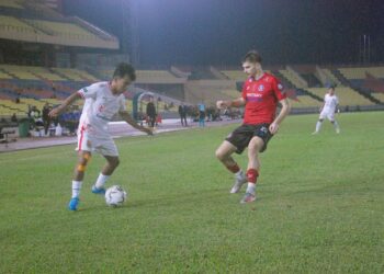 Pemain Kelantan Red Warrior FC cuba melepasi halangan pemain tengah Melaka FC, Dino Kalesic dalam aksi Liga Super di Stadium Hang Jebat malam ini. UTUSAN/AMRAN MULUP
