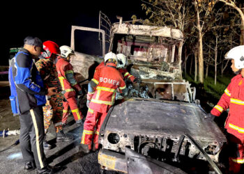 Anggota bomba Ayer Keroh mengeluarkan mayat mangsa yang rentung dalam kemalangan di Kilometer 193.8 Lebuhraya Utara–Selatan (PLUS) arah selatan awal pagi tadi.- FOTO IHSAN JSPT