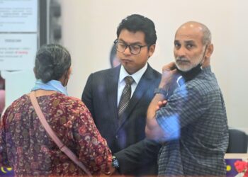 K. Selvanathan (kanan) bersama Muhammad Amirull Afiqq Mohamad Lokman berbincang selepas selesai prosiding pertuduhan kes anaknya di Mahkamah Kuantan di Kuantan, Pahang. - UTUSAN/SHAIKH AHMAD RAZIF