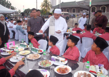 AHMAD Zahid Hamidi menyampaikan sumbangan kepada pelajar tahfiz Majlis Santunan Kasih Ramadan dan Iftar Jamaie Mega di Dataran Pusat Islam Masjid Al-Azim, hari ini. - UTUSAN/AMRAN MULUP