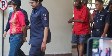 HALILA Abu Bakar (kiri) dan M. Jegathesan (dua dari kanan) diiringi anggota polis ketika dihadapkan ke Mahkamah Majistret George Town, Pulau Pinang atasu pertuduhan melakukan kelucahan melampau di tanah perkuburan Cina di Batu Gantung, Ayer Itam, pada 22 Mac lalu. - UTUSAN/DANIAL SAAD